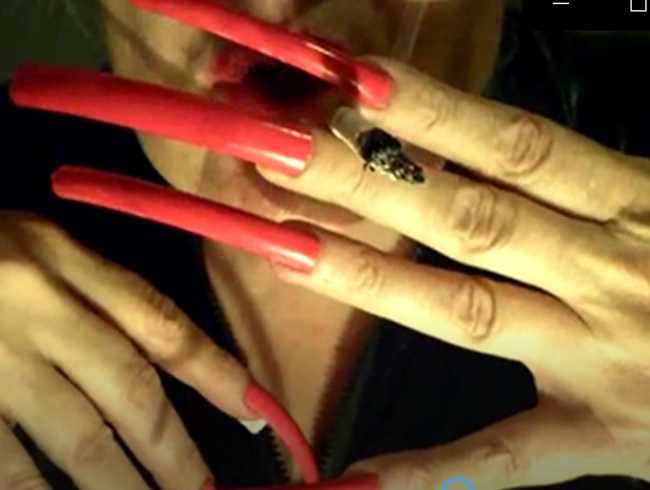 die Lady raucht mit langen Fingernägeln in schwarzem latexoverall