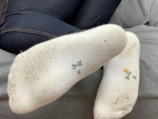 Süße Füße in dreckigen weißen Socken